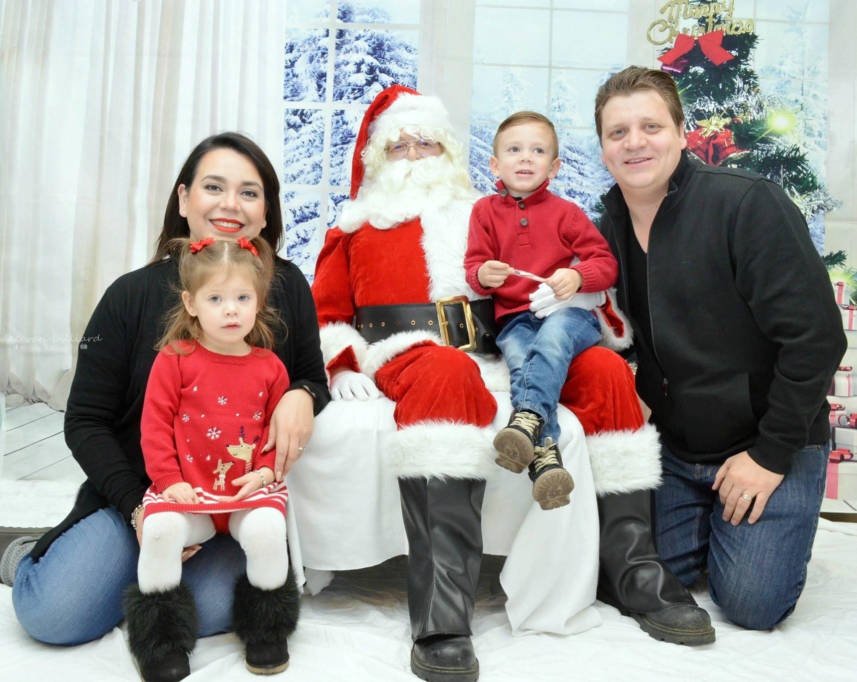 A family of four posing with Santa Claus.