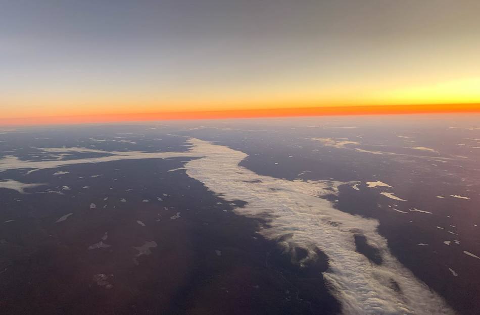 A photo from the plane window shows the curvature of the earth and all of its colors.