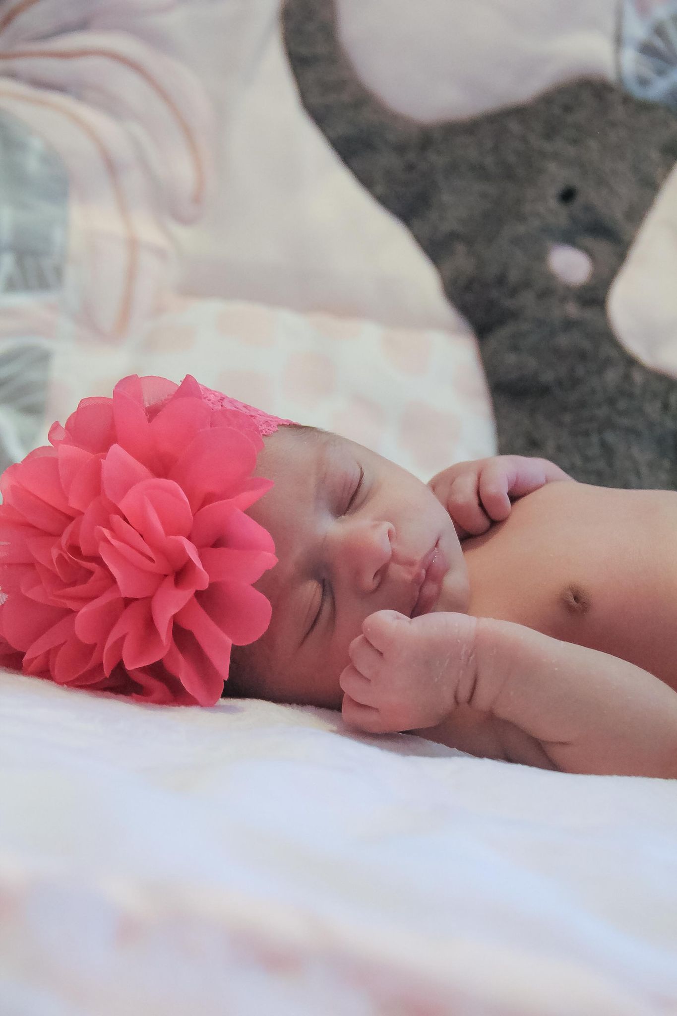 A young girl with a floral bow peacefully asleep.