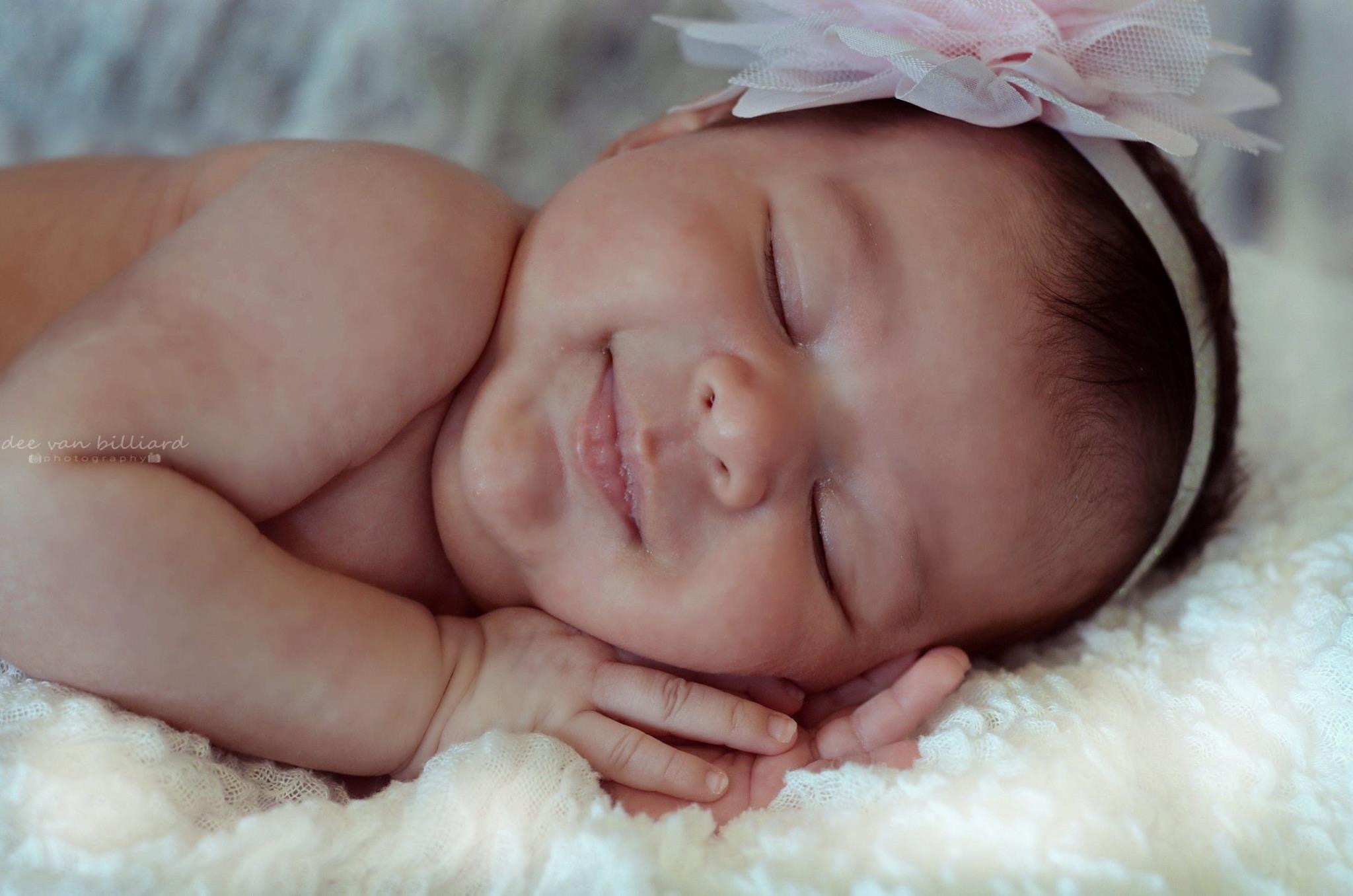 A baby girl lying on its side, peacefully asleep.
